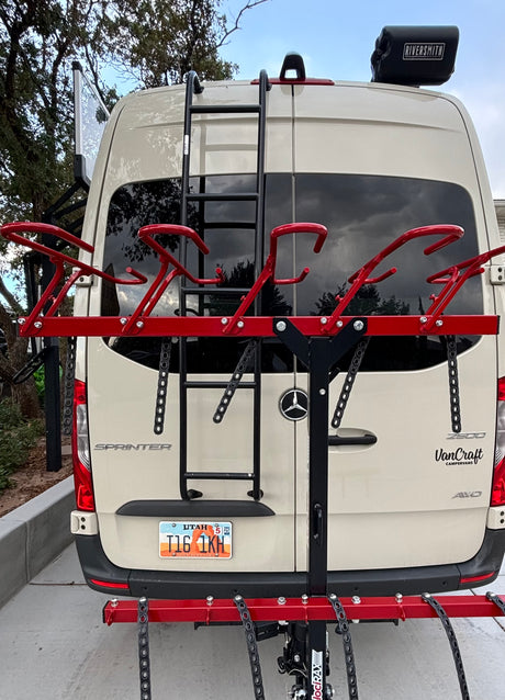Rear view of a Mercedes Sprinter RV rental camper van, equipped with a ladder and a multi-bike rack for outdoor fun.