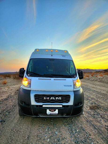 Stunning white RV rental van at sunset in a vast desert landscape, ready for your next adventure.