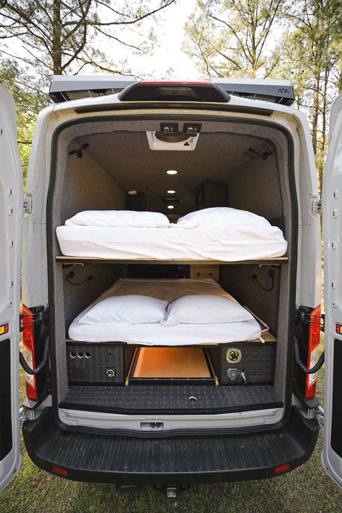 Inside a spacious RV rental, this custom camper van features bunk beds & smart storage for comfortable travel.