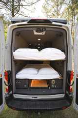 Inside a spacious RV rental, this custom camper van features bunk beds & smart storage for comfortable travel.