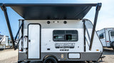 A white and gray Sportsmen Classic travel trailer with a large black extended awning, perfect for an rv rental.