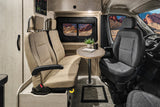 Modern RV rental interior: comfortable swivel seats, dining table, and a scenic desert window view for your road trip adventures.