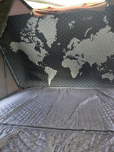 Cozy RV rental interior: a quilted world map adorns the ceiling above a matching, comfortable bed.