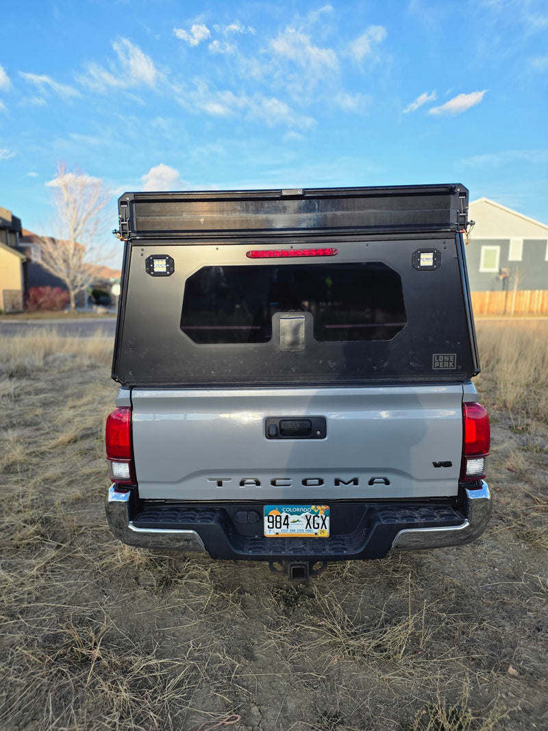 Rear view of a grey Toyota Tacoma with a Lone Peak overland camper shell, an ideal RV rental for outdoor adventures. — photo 10