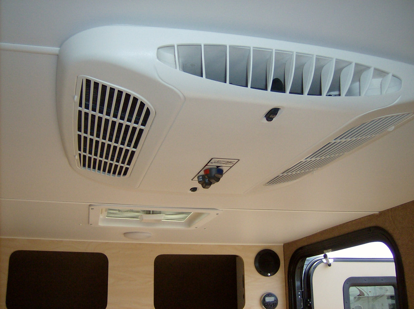 Stay comfortable in your RV rental with this clear view of the ceiling AC unit, featuring cool air vents & user controls.