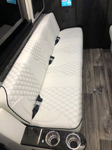 Experience comfort in this RV rental's custom luxury interior: white quilted seating, integrated cupholders, & control screen.