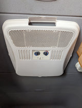 A white Dometic RV air conditioner/heater unit, with visible fan and temperature controls, typical in an rv rental.