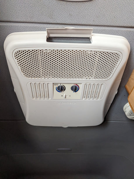 A white Dometic RV air conditioner/heater unit, with visible fan and temperature controls, typical in an rv rental.