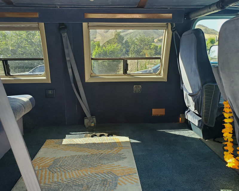 RV rental interior: Spacious back area with comfortable seating, dual windows offering scenic views, and soft carpeting. — photo 6