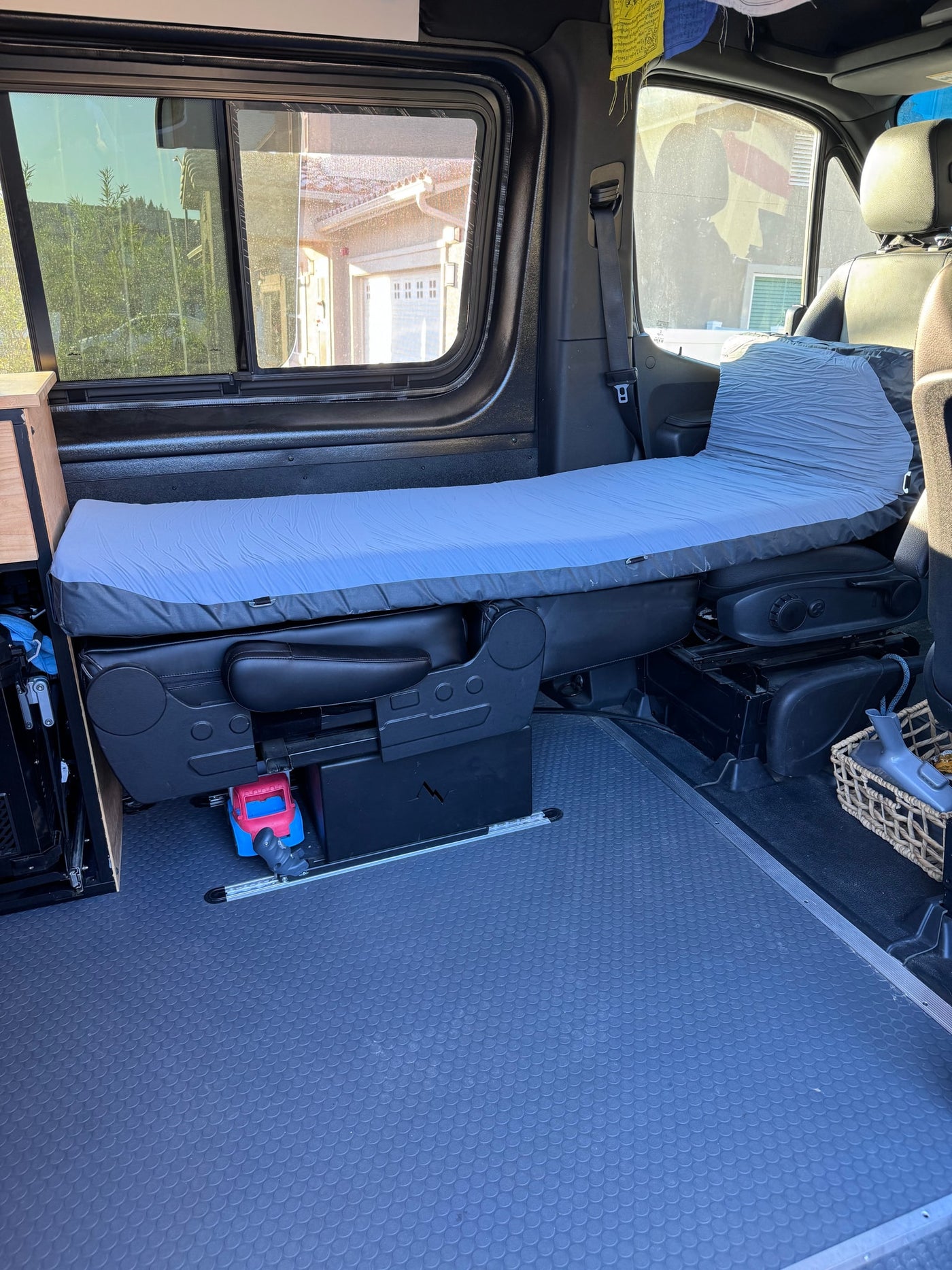 RV rental camper van interior featuring a modular bed, textured floor, and large windows with outdoor views. — photo 5