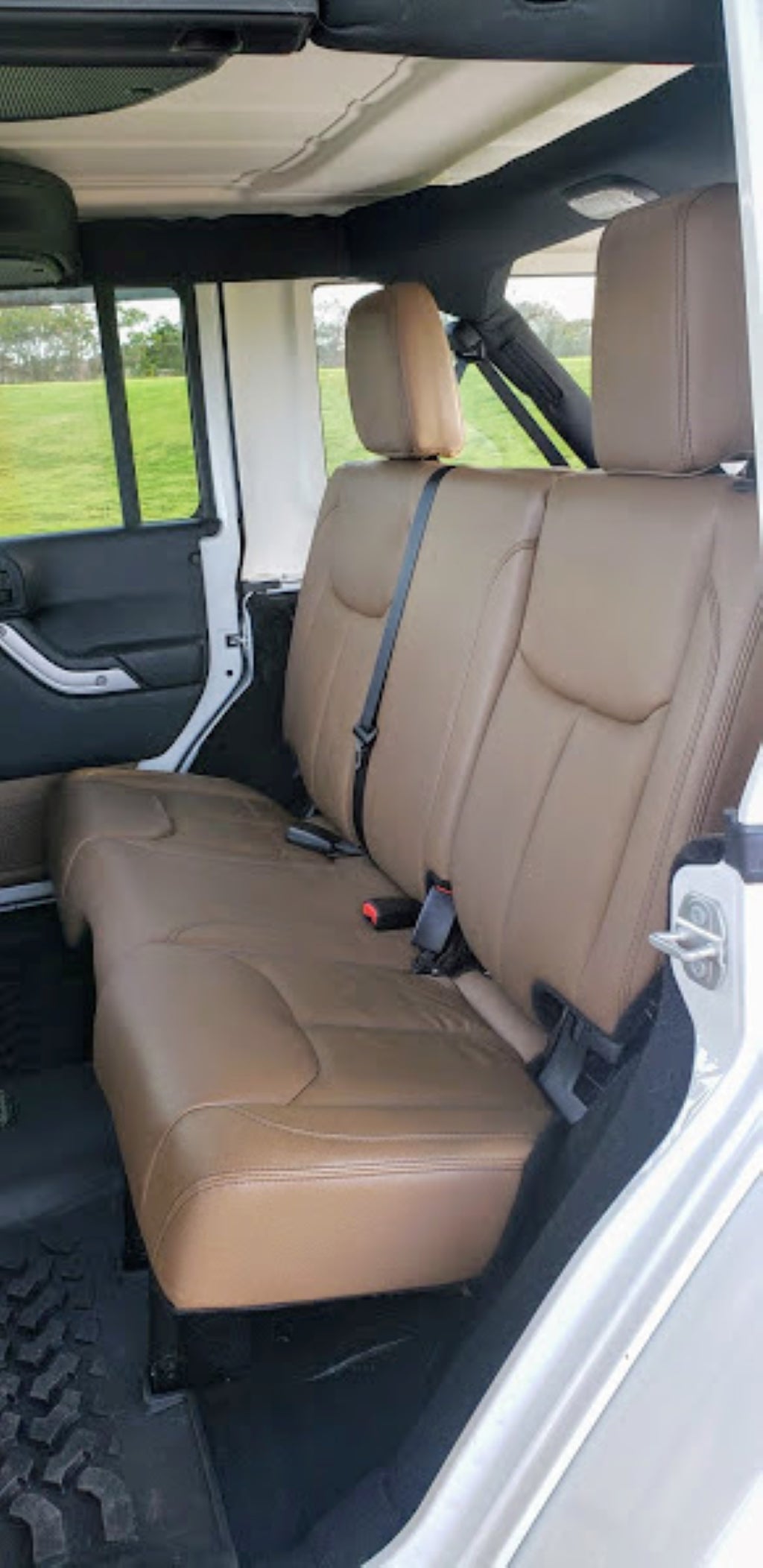 Tan rear seats and spacious open-air interior of a 4x4 vehicle, like a Jeep, for your RV rental adventure.