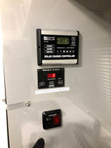 RV rental control panel showing solar charge (12.7V), tank monitor (0% shown), and water heater switch for system management.