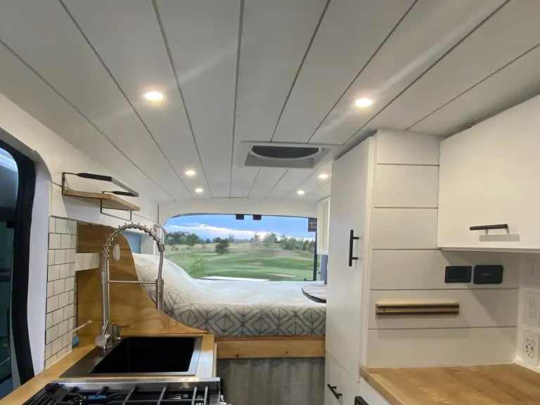 Spacious RV rental interior with a cozy bed, full kitchen, and scenic view, perfect for mobile living adventures. — photo 19