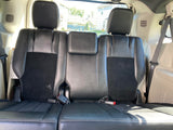 RV rental: Interior view of black third-row seating with white stitching and visible seatbelts.