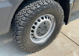 A close-up view of a rugged BFGoodrich all-terrain tire and Mercedes wheel on an RV rental van, ready for the road.