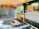 RV rental interior: cozy bed, compact kitchen with sink & Dometic cooler, ready for adventures.