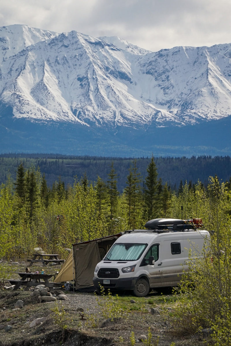 RV rental camper van set up for scenic mountain camping with an awning & picnic tables. Perfect for nature lovers. — photo 2