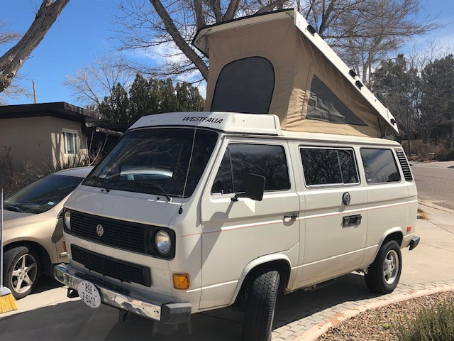 White VW Westfalia camper van with extended pop-top, perfect for an RV rental road trip adventure.