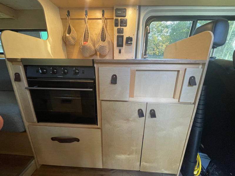RV rental kitchen: compact interior with oven, storage, and control panel for mobile adventures. — photo 3