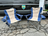 Two folding chairs sit before an RV rental van, featuring an "Outdoorsy" sticker. Ready for your next adventure!