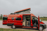 Vibrant red Winnebago Solis camper van with an open pop-top and interior visible, perfect for an RV rental.