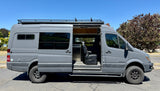 Spacious grey custom camper van with open side door revealing its interior, perfect for your next rv rental adventure.