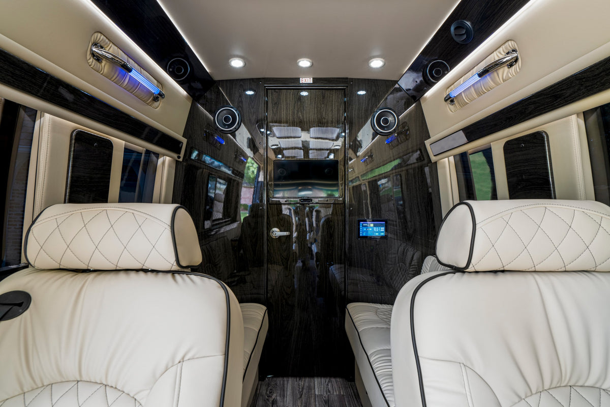 Step inside this luxury RV rental featuring cream leather seats, dark wood paneling, ambient lighting, and entertainment. — photo 17
