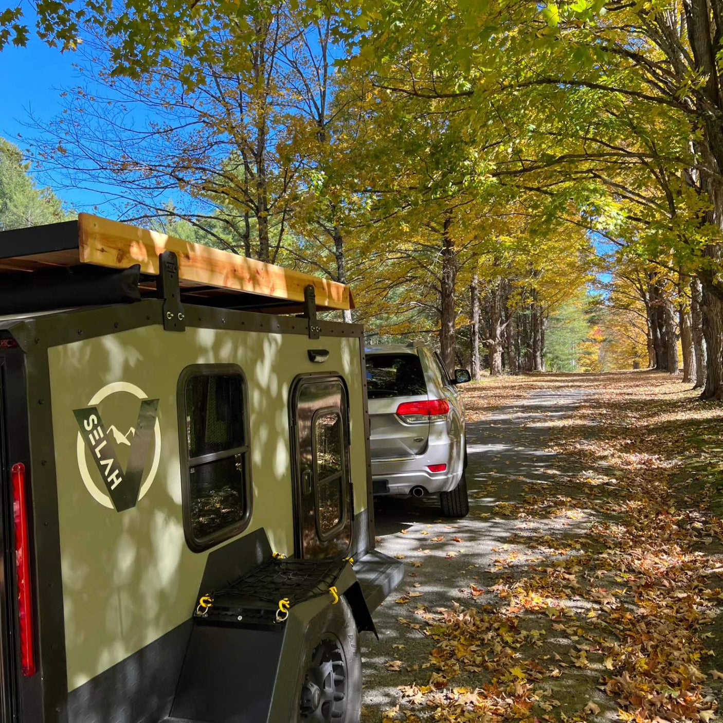 Selah camper on an autumn road, ideal RV rental for scenic adventures surrounded by vibrant fall foliage.