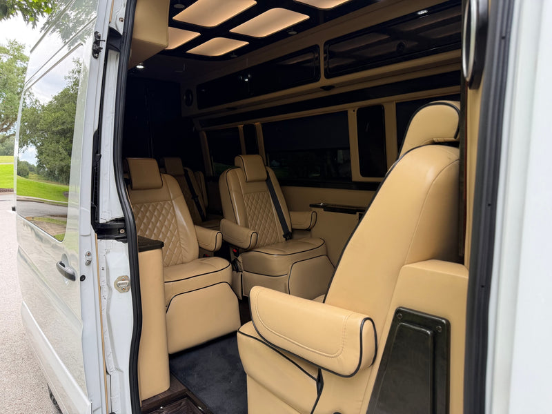 Upscale rv rental interior with tan captain's chairs, ambient ceiling lights, and elegant finishes. — photo 8
