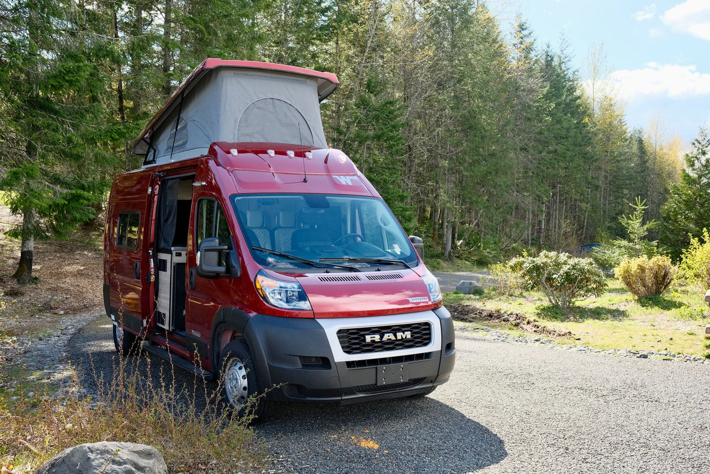  parked against a scenic mountain backdrop.|Red pop-top RV rental — photo 3