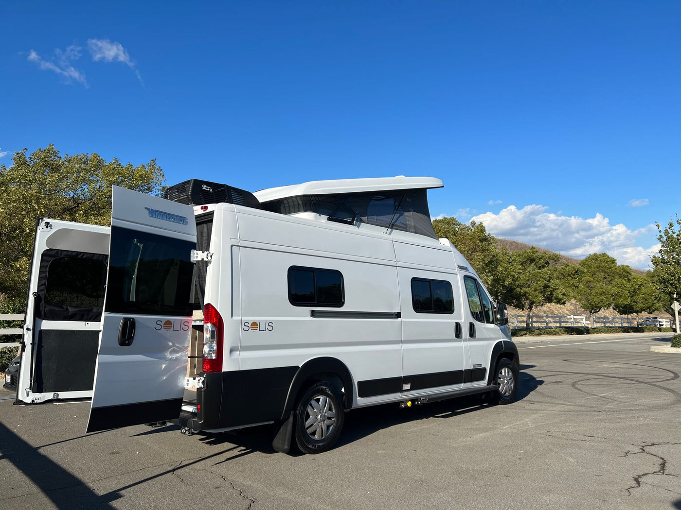  compact white RV rental bathroom featuring a Thetford toilet — photo 12