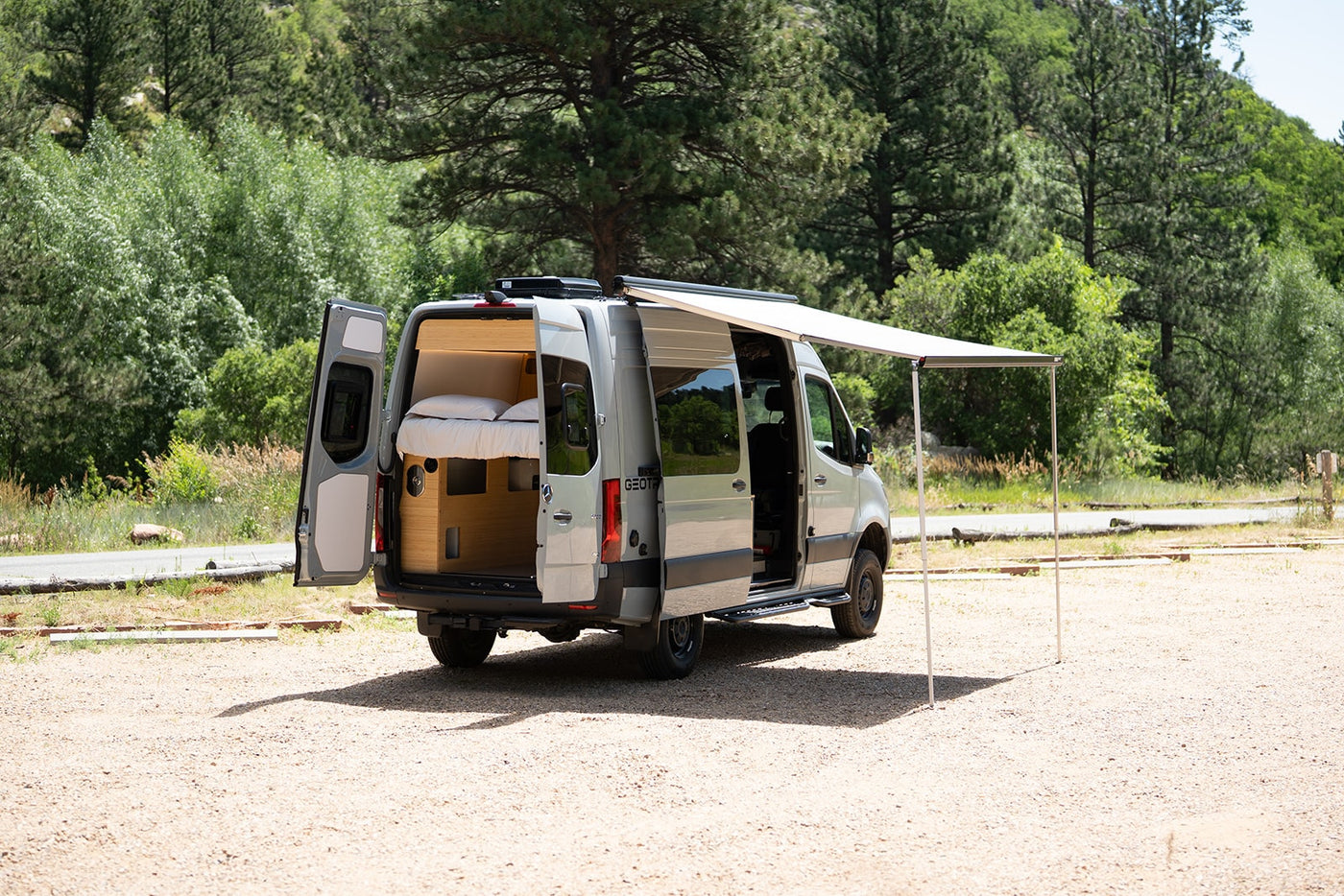 Explore this RV rental's spacious interior, complete with bed, and outdoor awning setup, ready for adventure. — photo 14