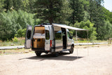 Explore this RV rental's spacious interior, complete with bed, and outdoor awning setup, ready for adventure.