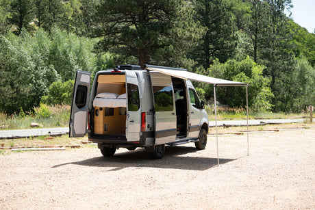 Explore this RV rental's spacious interior, complete with bed, and outdoor awning setup, ready for adventure.