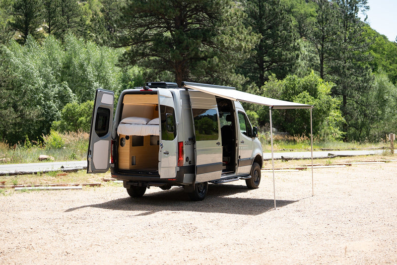 Explore this RV rental's spacious interior, complete with bed, and outdoor awning setup, ready for adventure. — photo 14