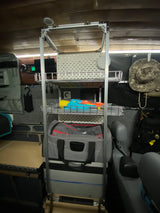 RV rental interior with a tall aluminum shelving unit. Provides organized campervan storage for cooler, bags, and toys, ready for adventure.