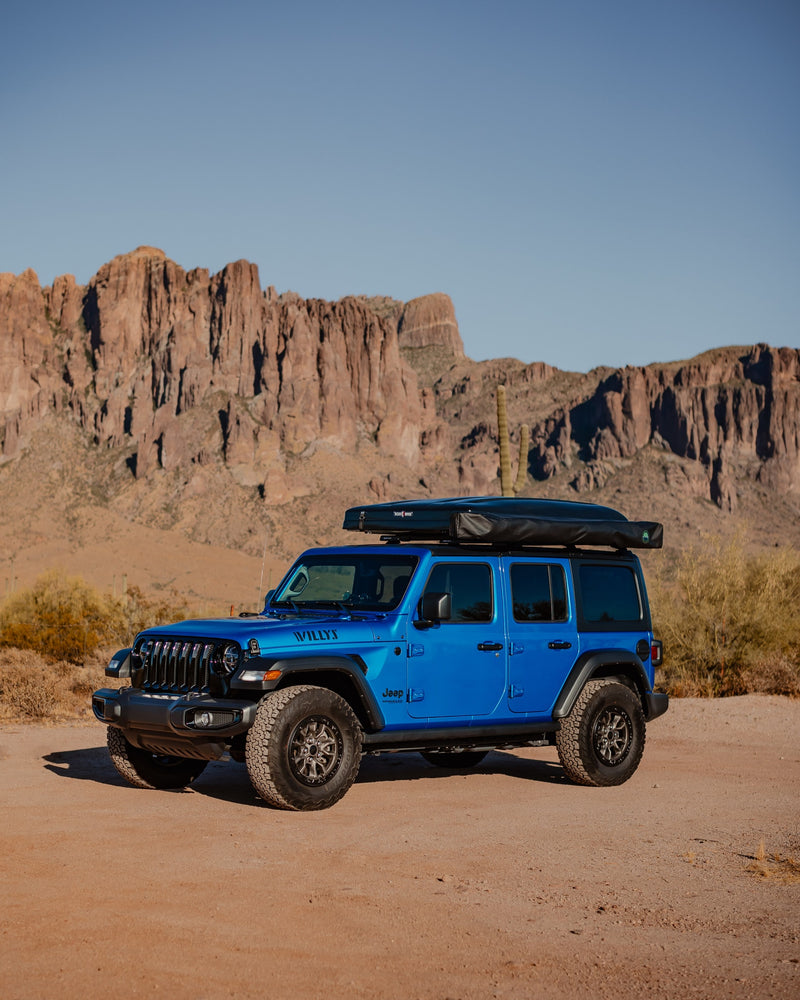 Blue Jeep Wrangler with rooftop tent, ready for your RV rental adventure in desert mountains. — photo 12