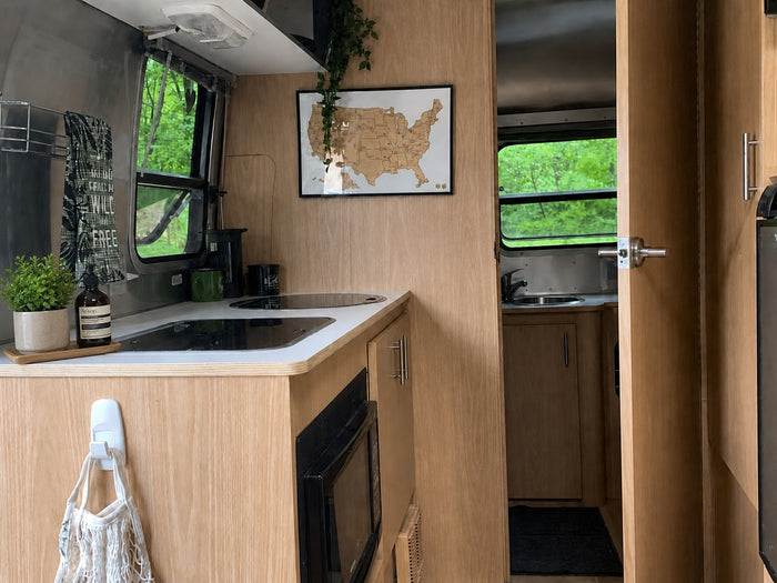  bathed in the glow of a sunset.|Cozy rv rental kitchen with a beautiful lakeside view. Features a modern cooktop