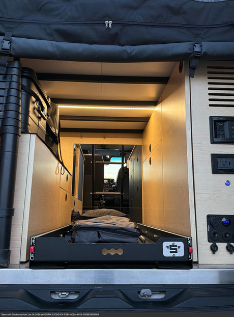 Inside a well-equipped RV rental, featuring a pull-out storage drawer, cozy LED lighting, and accessible power panel.