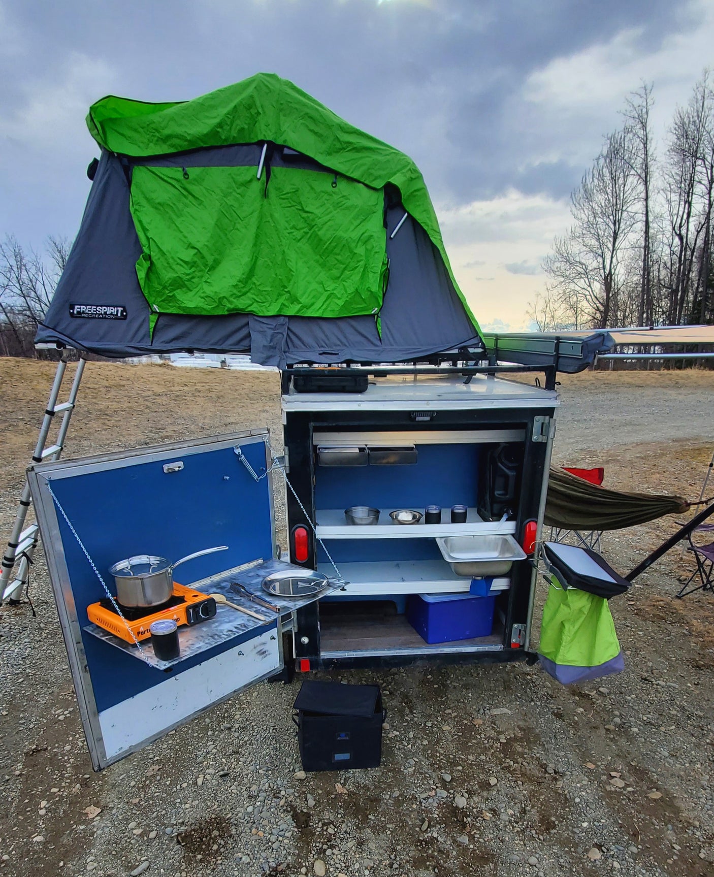 Mobile camping setup with rooftop tent & outdoor kitchen, perfect for your next RV rental adventure.