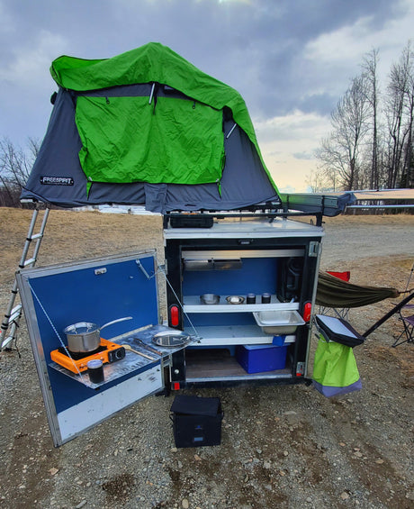 Mobile camping setup with rooftop tent & outdoor kitchen, perfect for your next RV rental adventure.