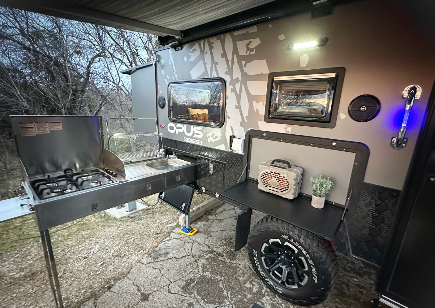 This off-road camper RV rental features a robust outdoor kitchen setup, perfect for adventurous camping.