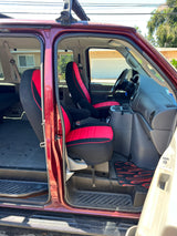 Spacious van interior with red/black seats, ideal for rv rental adventures. Open side door reveals dashboard & rear area for travel.