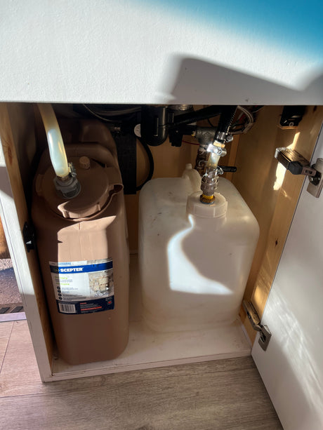 RV rental under-sink water system: a Shurflo pump connects fresh and grey water tanks for mobile living convenience.