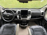 RV rental interior: clear view of the dashboard, Ram steering wheel, large infotainment screen, and detailed front seats.
