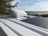 RV rental: rooftop solar panels, vent fan, and a serene water view from the van.