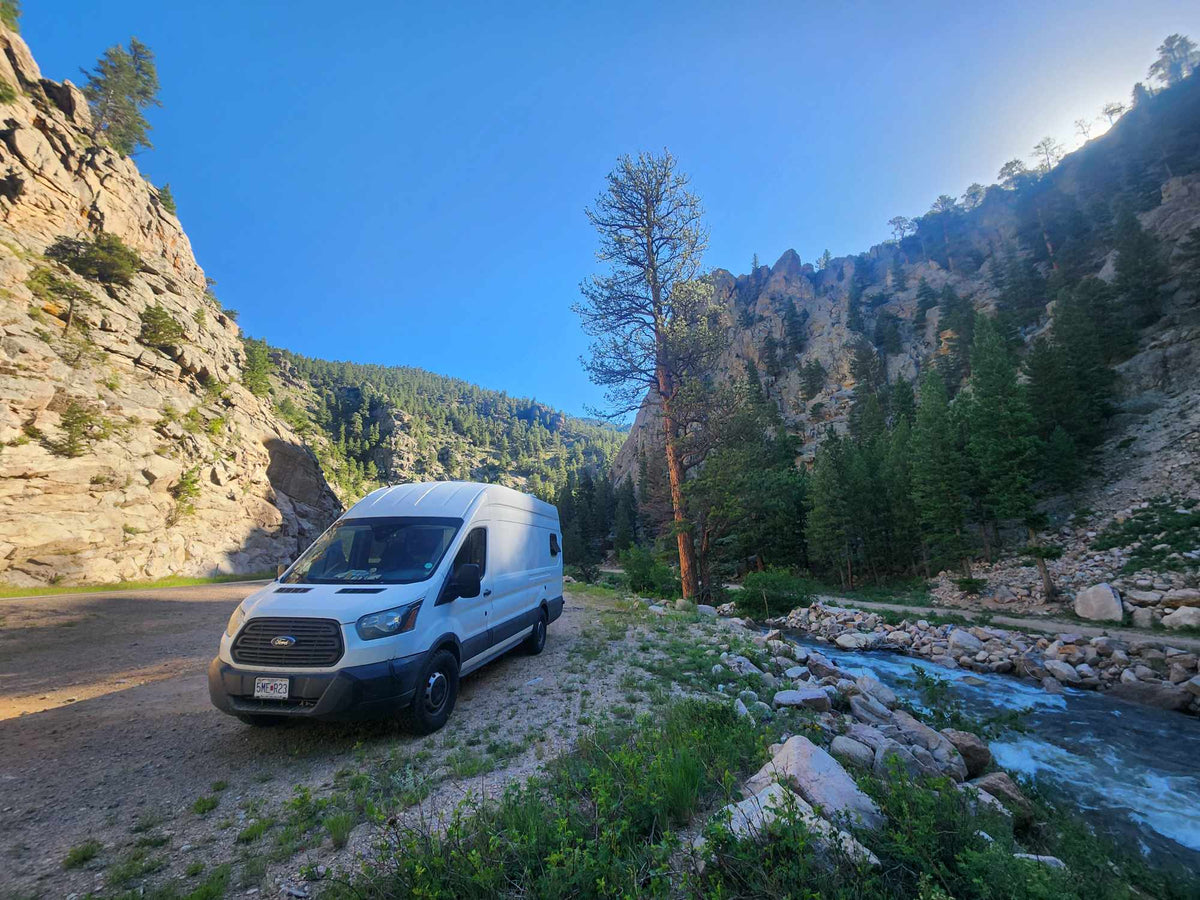  with a crescent moon above.|RV rental with a warm wooden interior. Features a compact kitchen with sink