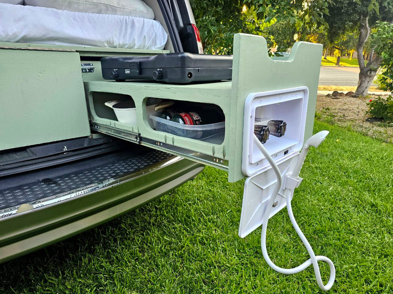 RV rental: View of a camper van's pull-out kitchen with stove and an integrated outdoor shower for camping convenience. — photo 20