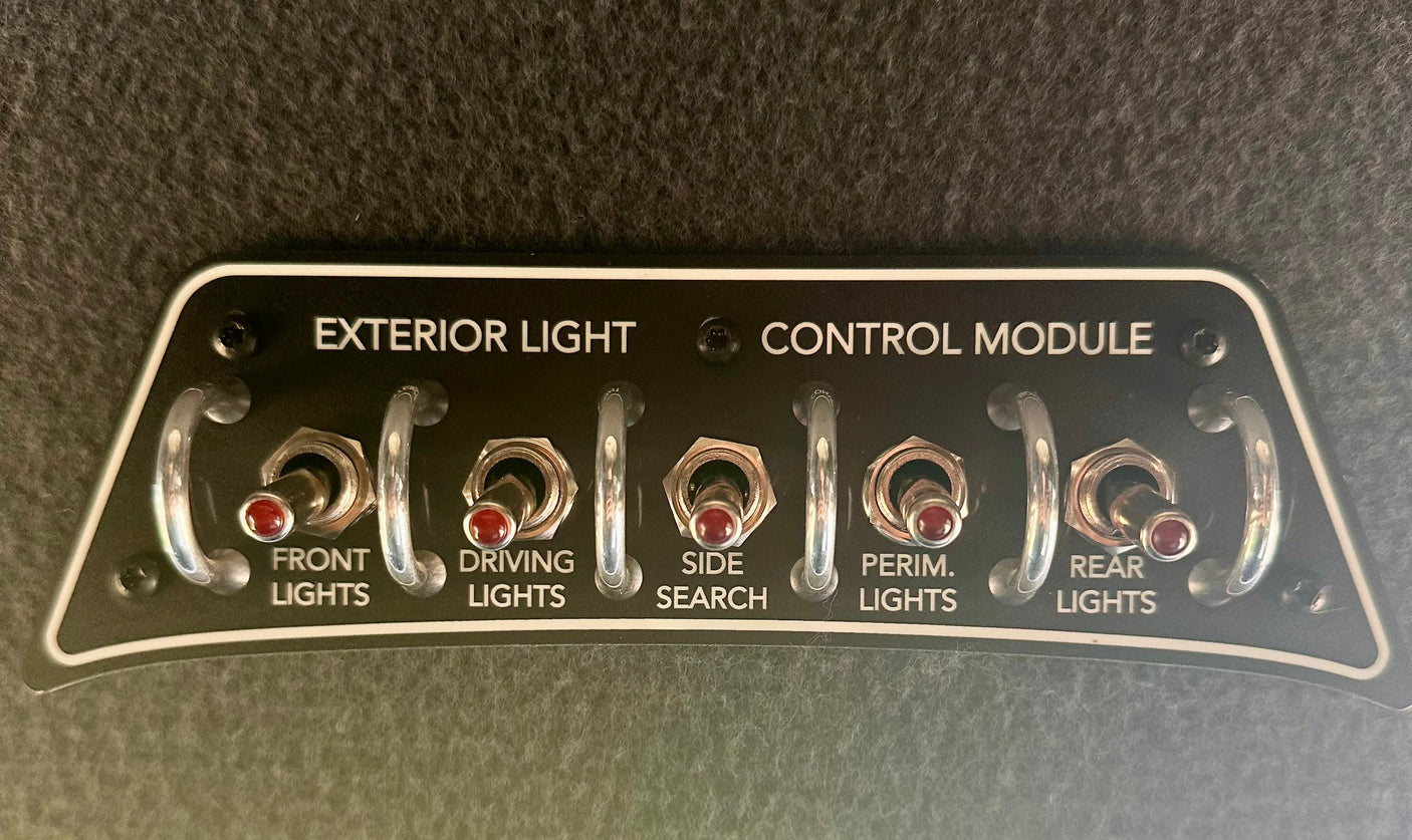 An rv rental exterior light control module, with five toggle switches for FRONT, DRIVING, SIDE SEARCH, PERIM., and REAR LIGHTS.