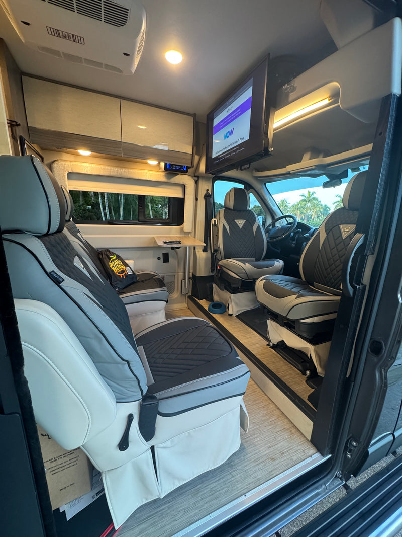 This comfy camper van rv rental interior offers swivel seating, TV, and climate control, ideal for mobile living. — photo 15
